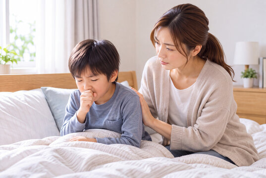 咳をする子どもの背中をさすって看病する母親