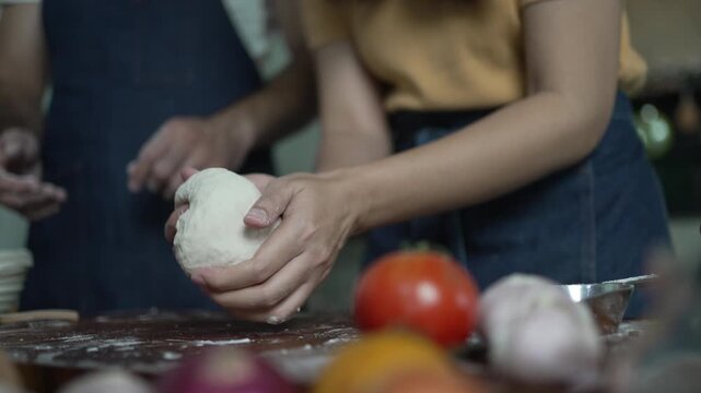 Woman's Hand Shapes a Ball of Pizza Dough