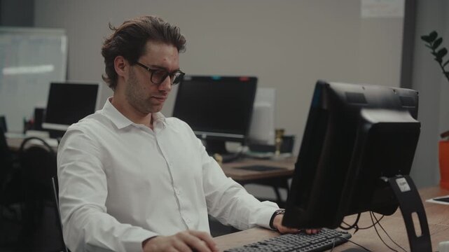 Exhausted overworked businessman experiencing discomfort typing on computer, feeling sharp pain in wrist, neck due to prolonged sedentary work. Concept of burnout, fatigue, health problems from work.