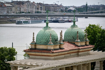 Decorative green copper domes of Varkert Bazar with the Danube River in the background in Budapest, Hungary © sebastiangora