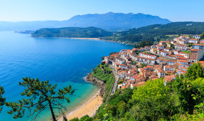 Panoramic view of coastal fishing village lastres in asturias spain under blue sky