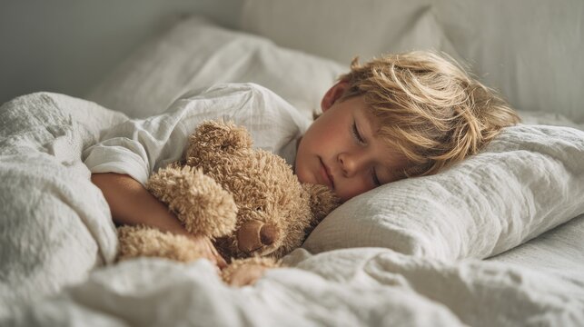 little boy sleeping in bed with toy bear in modern room