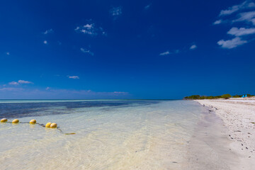 Tropical sandy beach and an exotic view of the Atlantic Ocean against a blue sky with clouds in Cuba, Caribbean – background for projects, wallpaper © anettastar