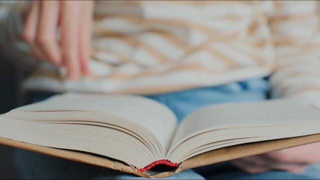 Young woman hands reading book in cozy living room, turning page, learning, studying, education, read notebook, stay home. Close up female turning papers, man relaxing at house. Literature novel