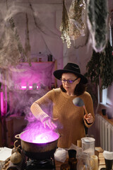 realistic witch witchcrafting, casting spells brewing potion in cauldron. Everyday life intertwined with traditional witchcraft, magic and mystical atmosphere. © Andrii Lysenko