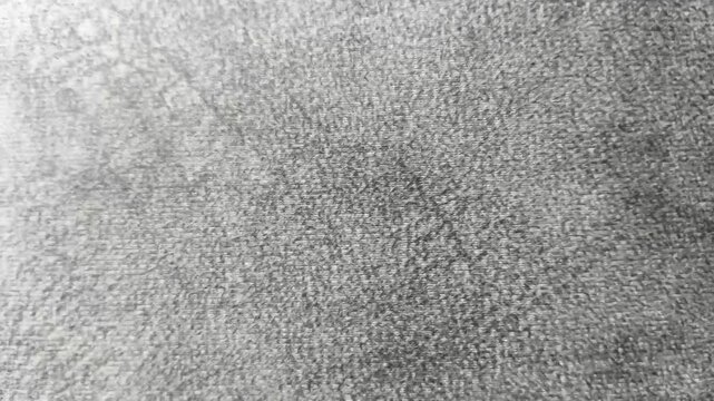 Stop motion loop animation of Faded old or retro style black, white and grey color denim jeans cloth or fabric sheet smooth surface abstract background texture with copy space. Closeup macro top view.