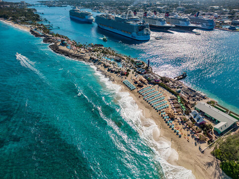 Nassau, The Bahamas - 28 December 2025: Aerial view of Royal Beach Club Paradise Island with rows of beach umbrellas, turquoise waters, and cruise ships docked in the harbor.