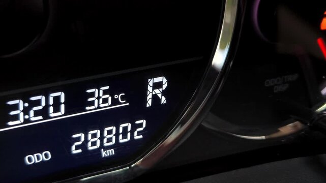 Close-up of digital car dashboard display showing reverse gear R status