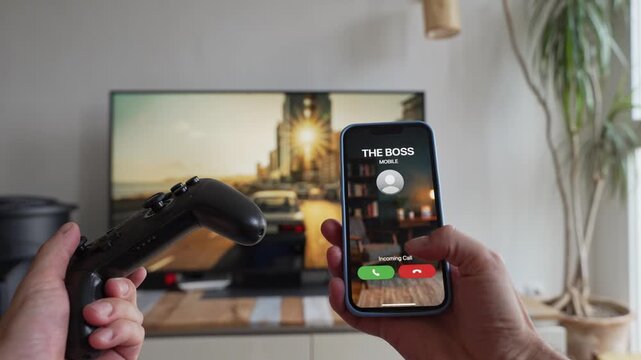 Man gaming receives an incoming call from his boss