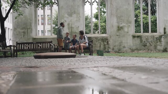 Family relaxing in St Dunstan in the East in London