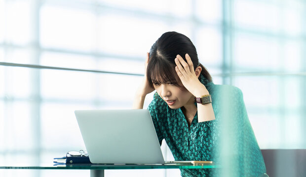 頭を抱えて悩む女性・ビジネスウーマン, Stressed Businesswoman Working on a Laptop