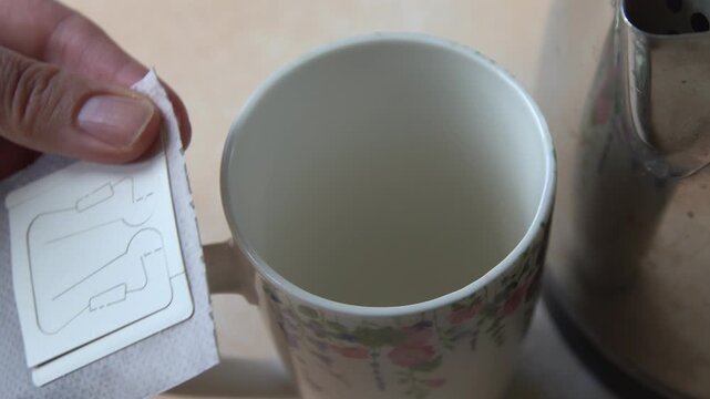 Pouring Hot Water into Drip Coffee Bag in Ceramic Cup Close Up