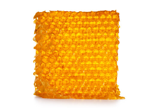 Piece of wax honeycomb filled with honey, isolated on white background.