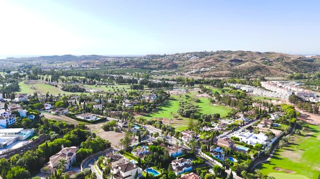 Drone sweeps round to reveal Mijas Golf Course in southern Spain at sunrise.