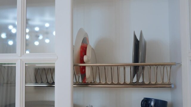 Bright kitchen shelf displaying neat dishes and mugs in cheerful arrangement