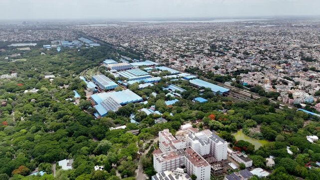 view of Integral Coach Factory (ICF), Perambur, Chennai, showcasing the sprawling railway manufacturing complex surrounded by extensive green spaces and dense urban neighborhoods. Large blue-roofed.