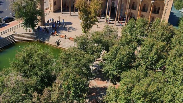 Panning, aerial shot of the Bolo Hauz Mosque in Bukhara, Uzbekistan, near the pool.