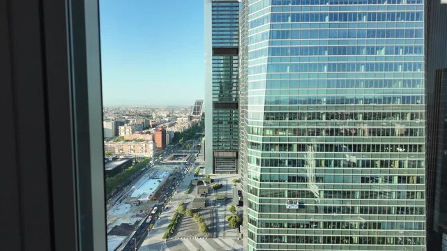 High angle view from Madrid's Cuatro Torres business district looking over glass office towers and city streets.