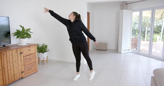 High speed photography for dynamic scenes, reaching for plant, woman in black hoodie stretching in m