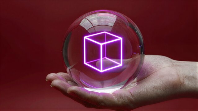 Hand holds glowing purple cube inside transparent sphere against red background.