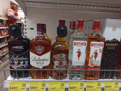 Zvyagel, Ukraine - January 06, 2026: Liquor store shelf displaying Ballantine's, Chivas Regal, Beefeater gin, and Ararat brandy with security tags and Ukrainian price labels.