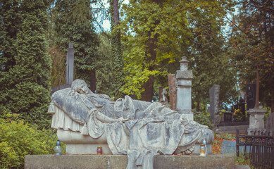Fototapeta premium Ancient European cemetery with stone angels and historic tombstones