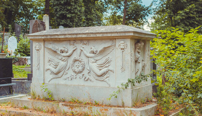 Fototapeta premium Ancient European cemetery with stone angels and historic tombstones