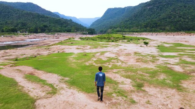 Lone tourist enjoying nature at bichanakandi with boder hills and dry river in bangladesh - aerial.