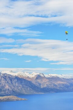 Paragliding over the snowcapped Remarkables mountain range, Queenstown, South Island, New Zealand