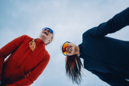 Laughing women keep running through winter training outdoors
