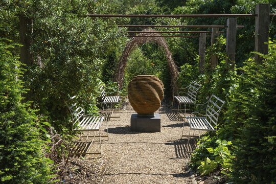 Layered steel sculpture surrounded by benches and gardens, Chelsea Physic Garden, historic botanical garden, oldest botanical garden in London, founded in 1673 by the Worshipful Society of Apothecaries, Chelsea, England, Great Britain