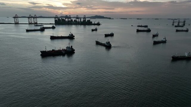 Aerial view oil and gas tanker ship offshore parking in sea, Crude oil tanker ship and LPG tanker ship offshore in bay at sunset, Silhouette oil and gas tanker ship.