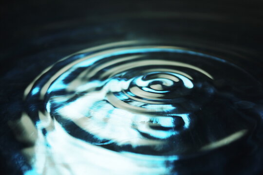 Close Up of Concentric Water Ripples on Dark Blue Aqua Surface