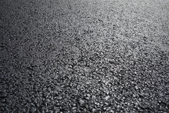 Dark black background created with an asphalt road