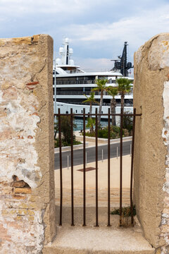 Luxury Superyacht Framed by Historic Stone Walls and Palm Trees in a Mediterranean Waterfront Marina