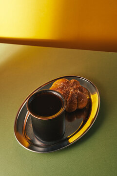 Black Coffee Mug with Sugared Pastry on Silver Tray