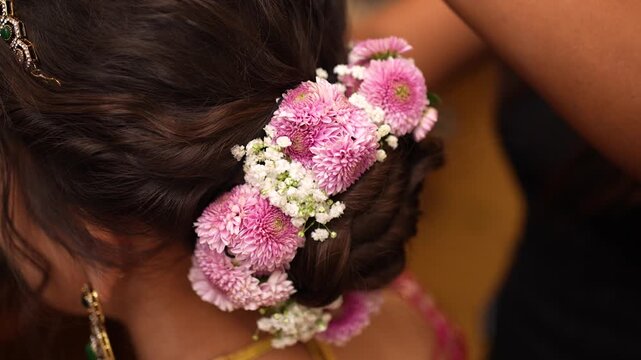 Indian bride getting her hair styled with fresh flowers in New Delhi