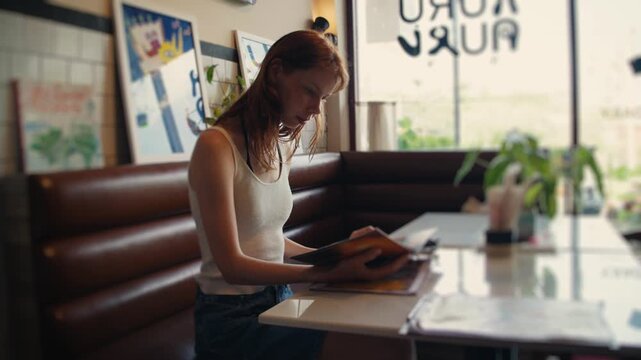 Young woman reading menu in retro diner
