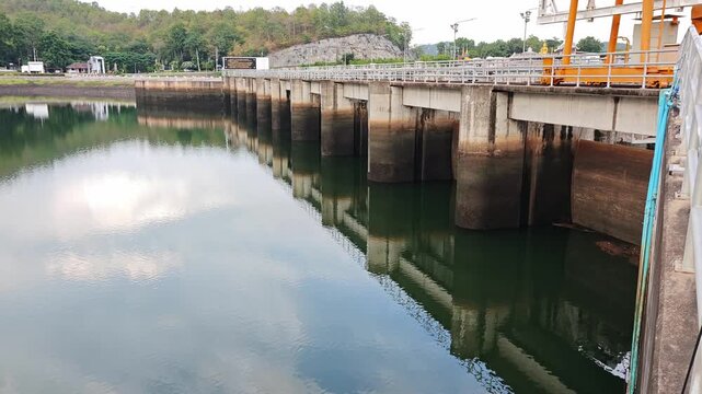 A large water release gate at a dam controlling the flow of water through a reservoir and downstream channel.