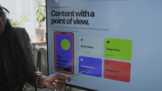 African American young adult woman pointing stylus at digital screen during business presentation. Clip highlights corporate training, marketing strategy workshops, agile workflow projects