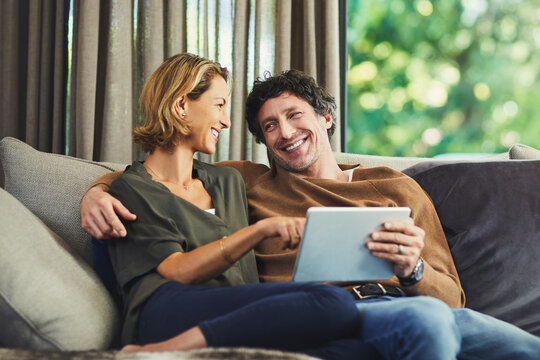 Pointing, streaming and tablet with happy couple on sofa in home living room for subscription signup. App, relax and smile with mature people in apartment together for online membership options