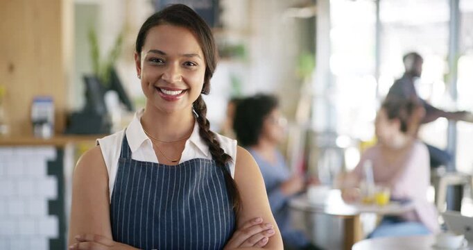 Arms crossed, face and portrait of waitress in coffee shop for friendly hospitality or service. Apron, food industry and small business with happy woman in cafe or restaurant for greeting or opening