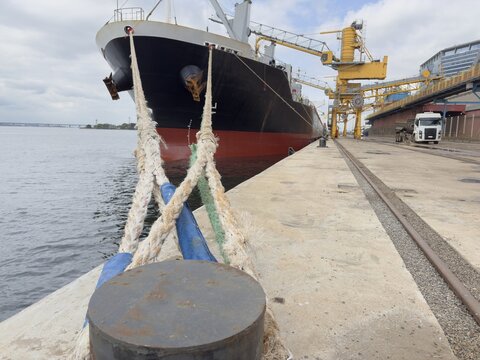 mooring lines of cargo vessel fasted to bollard at port.