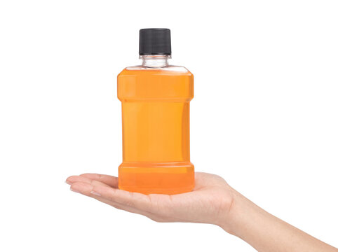 Bottle of orange mouthwash held by hand on transparent background for dental hygiene advertising.