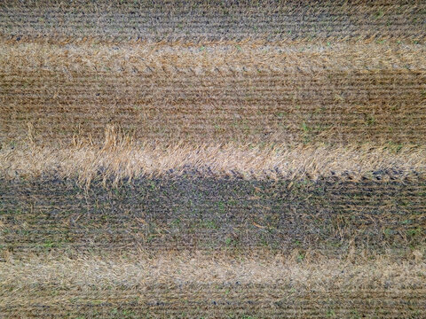 Aerial view of a harvested field with textured soil and straw patterns in Kempele, North Ostrobothnia, Finland.