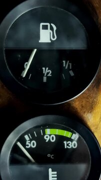 Vertical video social media - Closeup of the rising needle of an analog fuel gauge in an old car, after the ignition has been switched on, to show how much petrol or gas is in the tank.