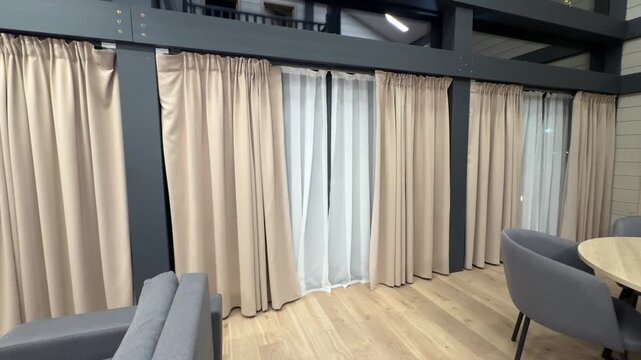 Automated window treatments in a rural house open and close on schedule, welcoming daylight and shutting for privacy, smooth quiet motion, candid authentic life at home.
