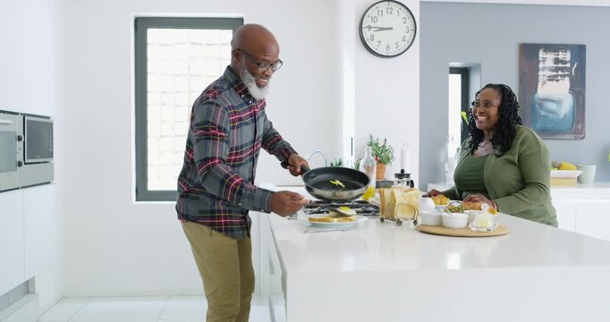 Smile, old couple and cooking in kitchen for breakfast, healthy food and bonding for nutrition. Happy, African people and frying eggs in home with partner, meal prep and homemade brunch on retirement