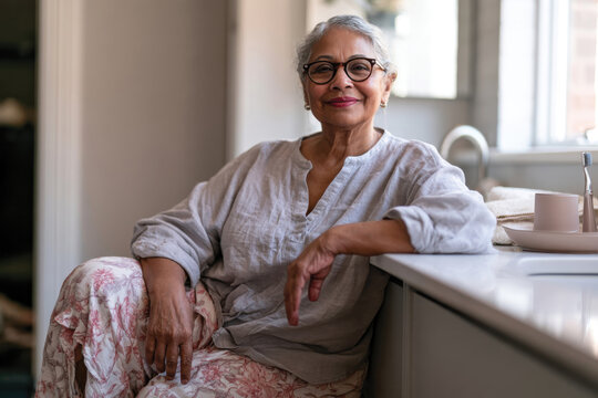 A graceful elderly woman poses confidently in a modern setting, highlighting her wisdom, inner beauty, and embracing life's experiences with joy and pride.