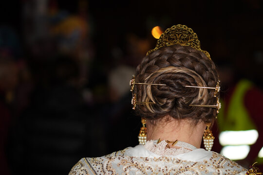 The back of a traditional Valencian fallera hairstyle, featuring a central braided bun (rodet)